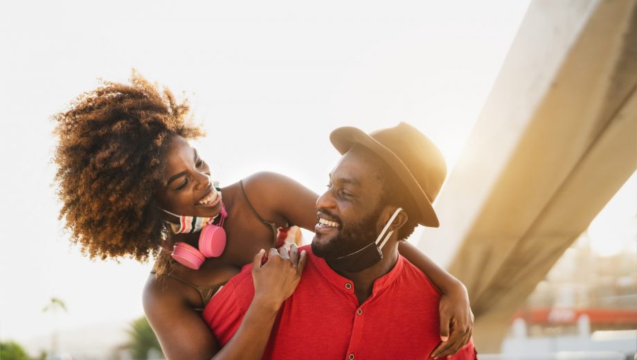 Happy African couple piggyback outdoor during corona virus pande